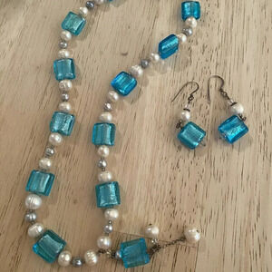This necklace and earring set features aqua blue molded glass beads and a pearl—